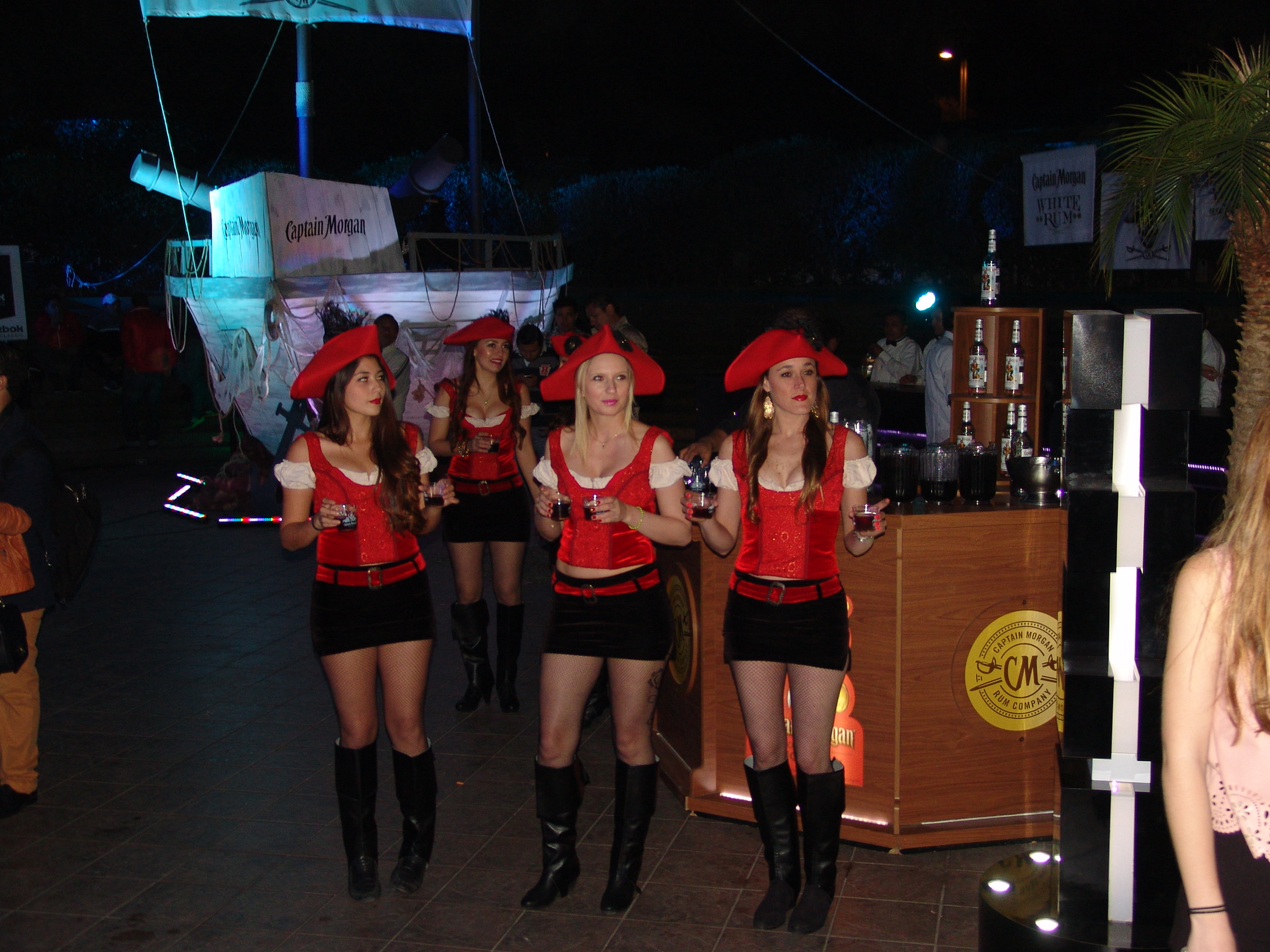 Edecanes con uniforme Captain Morgan en activación BTL nocturna junto a barco pirata decorativo y barra de servicio, TR3Z México