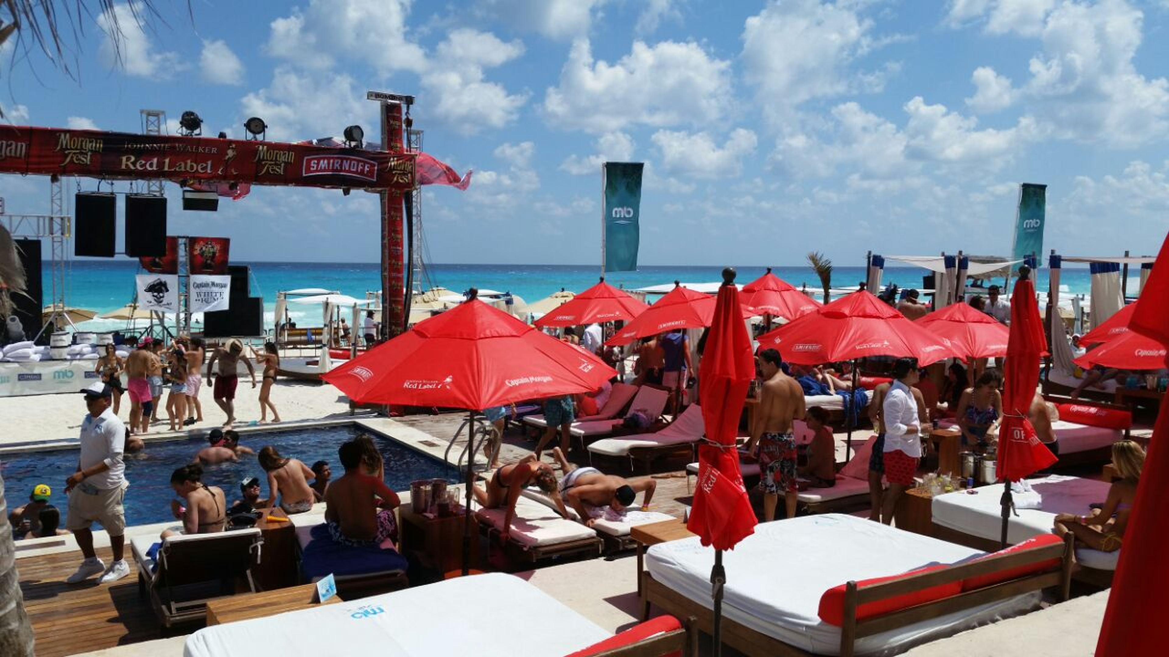 Morgan Fest Cancún con escenario frente al mar, sombrillas brandadas y área de alberca, producción de eventos masivos TR3Z Cancún